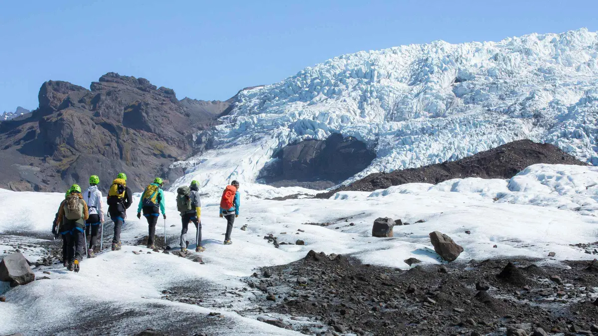 Hikers in crampons crossing the ridged ice on the easy Falljökull glacier hike above Skaftafell, Southeast Iceland