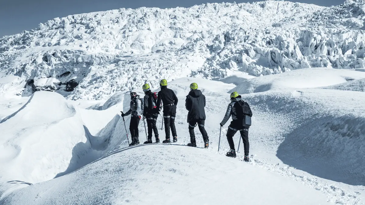 A guided group high on the upper icefall during the advanced Falljökull glacier hike in Skaftafell National Park, Iceland
